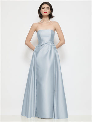 Light blue strapless satin column dress with waist bow and draped overskirt