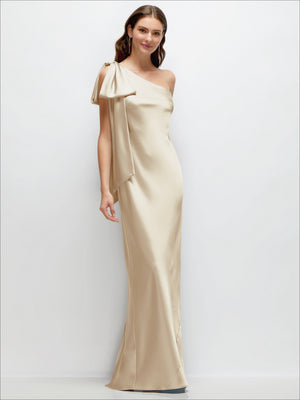One-shoulder satin maxi dress in champagne with cascading shoulder bow and side slit