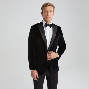 Men's black velvet tuxedo jacket with peak lapel and satin trim; bow tie visible.