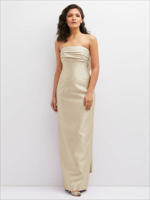 Champagne strapless column dress with draped bodice and side slit; oversized bow detail
