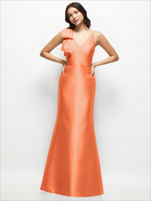 Orange satin trumpet dress with deep V neckline and one-shoulder cascading bow detail