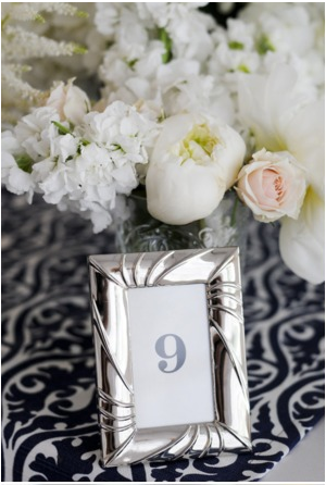 navy blue and white table at wedding silver photograph frame with rose flowers