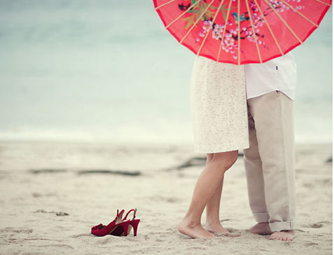 Image via Caroline Tran Couple holding red parasol for engagement photo shoot